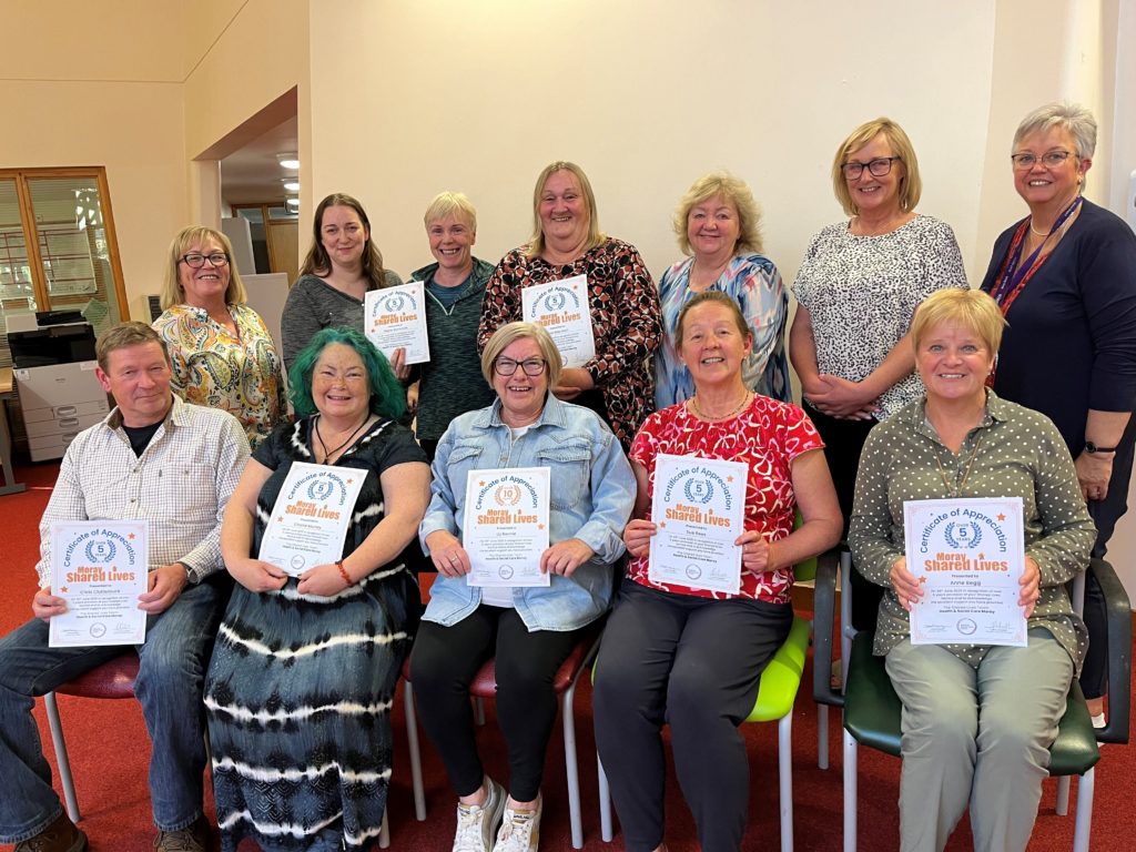 A group of Shared Lives carers proudly show off their certificates of appreciation.