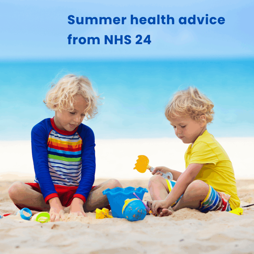 Two young children in shorts and T-shirts sit playing on the golden sand of a beach as the blue sea sparkles behind them.